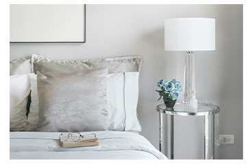 white bedroom interiors, white bedding and white lamps on a mirrored bedside table and acrylic bedside table